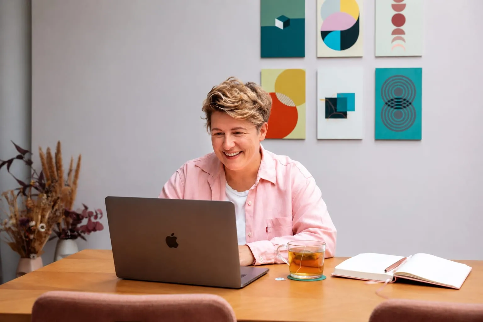 Monique tijdens een online coachingsessie achter haar laptop, met een kop thee